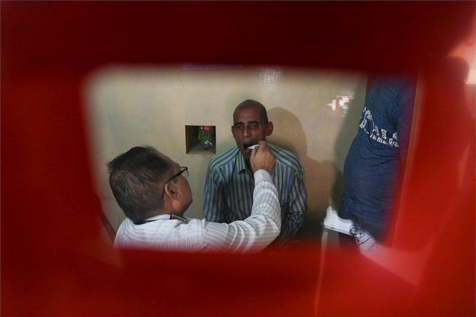 In this photograph taken on September 26, 2019, a doctor checks a suspected tuberculosis (TB) patient at a DOTS (directly observed treatment, short-course) Centre in New Delhi