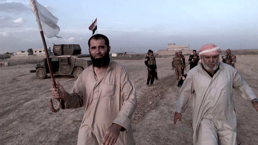 A man holds up a white flag as he walks towards special forces troops in Kukjali (31 October 2016)