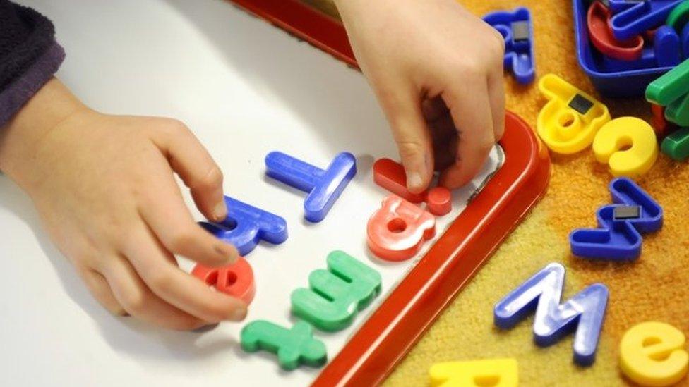 Primary school child, working in class with plastic letters