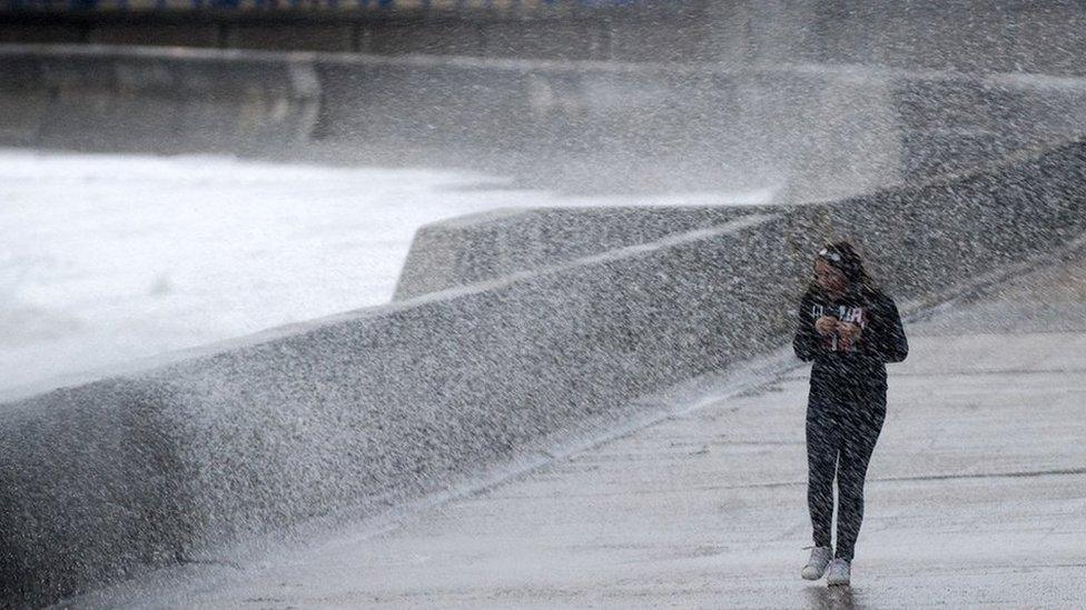 A woman being sprayed by the high tide