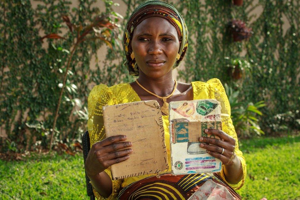 Woman holding up exercise books