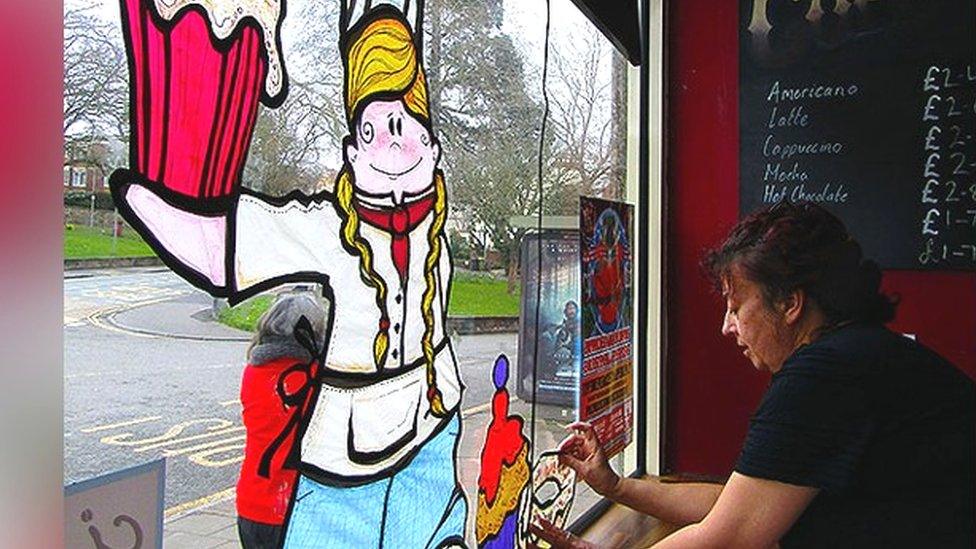 A woman working on window art