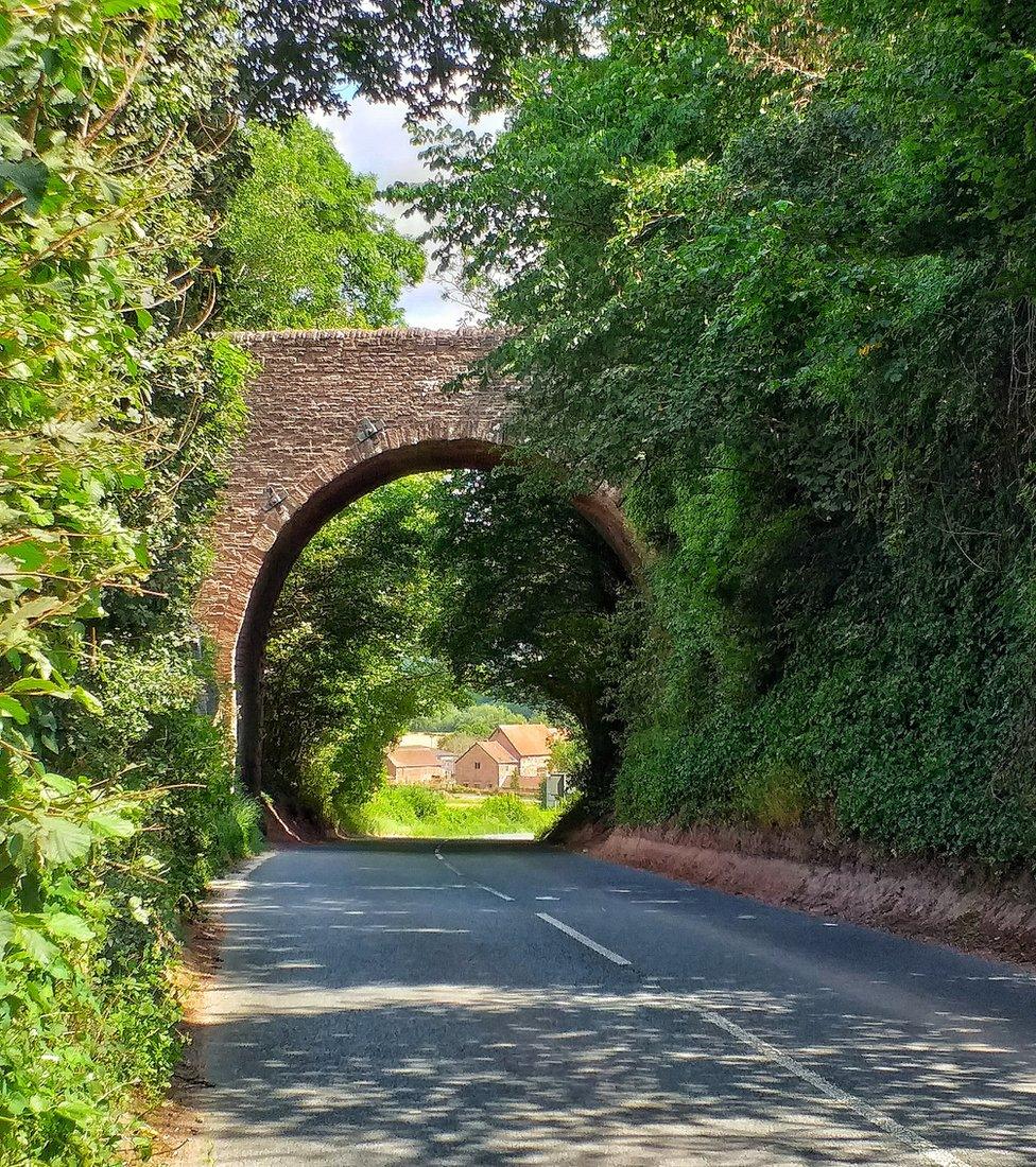 Houses seen through a bridge arch