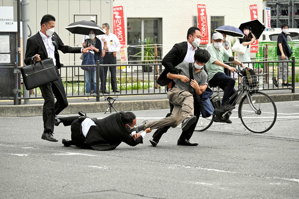 A man, believed to have shot former Japanese Prime Minister Shinzo Abe, is tackled by police officers in Nara, western Japan, 8 July, 2022 - in this photo taken by The Asahi Shimbun