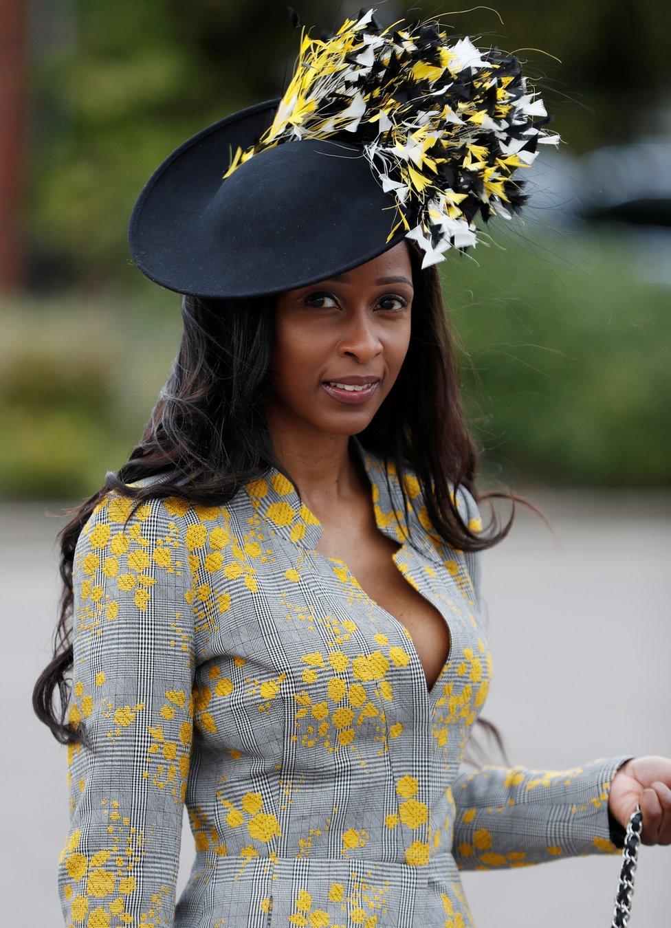 A racegoer poses as she arrives