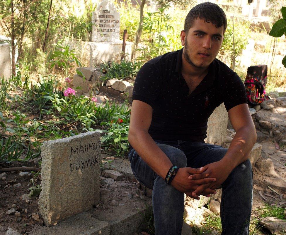 Firat Duymak, 18, next to his father's grave in Cizre, Turkey - May 2016