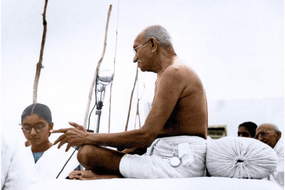 Mahatma Gandhi speaking, India, 1946. Left: Manu Gandhi.