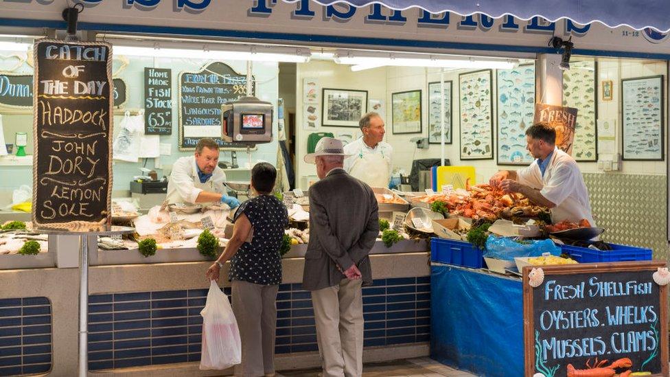 Customers at a fish stall in St Helier, Jersey