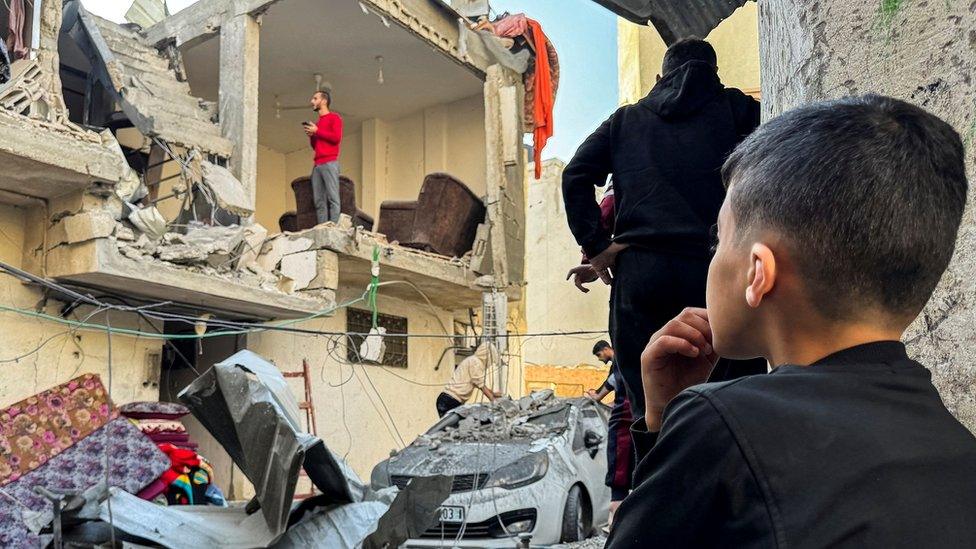 A Palestinian boy looks on at the site of Israeli attacks on a house in Khan Younis in the southern Gaza Strip