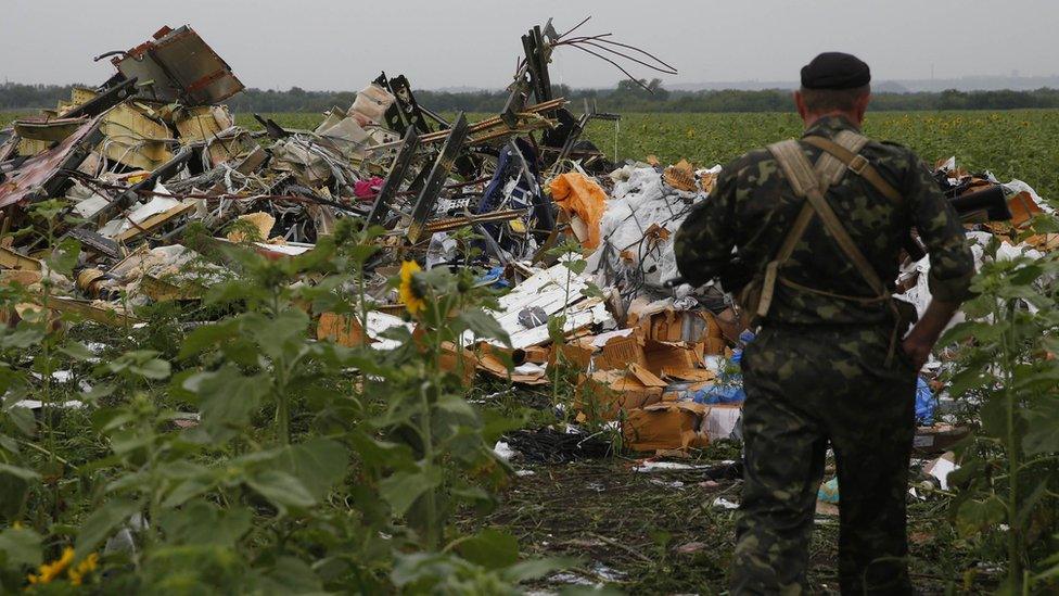 Pro-Russian separatist next to debris of MH17, 18 Jul 14