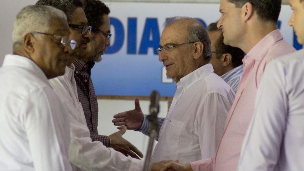 FILE - In this Dec. 3, 2014 file photo, Humberto de la Calle, head of Colombia"s government peace negotiation team, center, talks with Ivan Marquez, chief negotiator for the Revolutionary Armed Forces of Colombia (FARC), after a joint statement in Havana, Cuba. Declaring that "peace is near," Colombia"s President Juan Manuel Santos announced a surprise trip Wednesday, Sept. 23, 2015