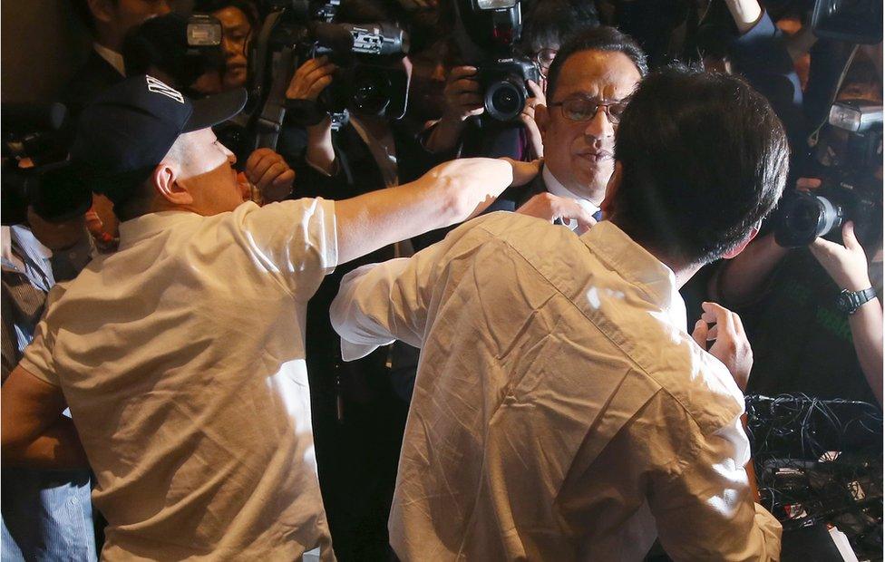 Atar Safdar (C), the head of Oxy Reckitt Benckiser Korea, is surrounded by the aggrieved relatives of victims as he bows during a press conference at a hotel in Seoul on 2 May 2016.