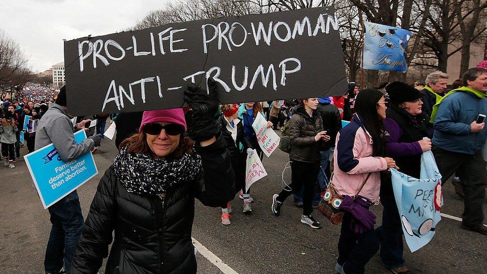 Protester holds sign saying Pro-Life Pro-Woman Anti-Trump