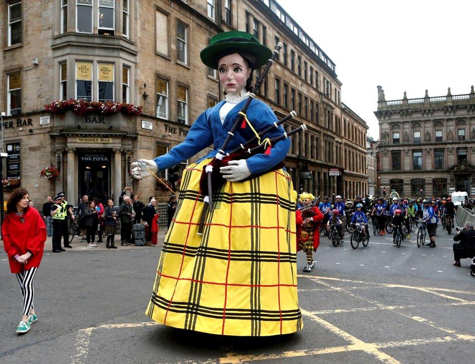 A giant piper leads the procession during the opening ceremony