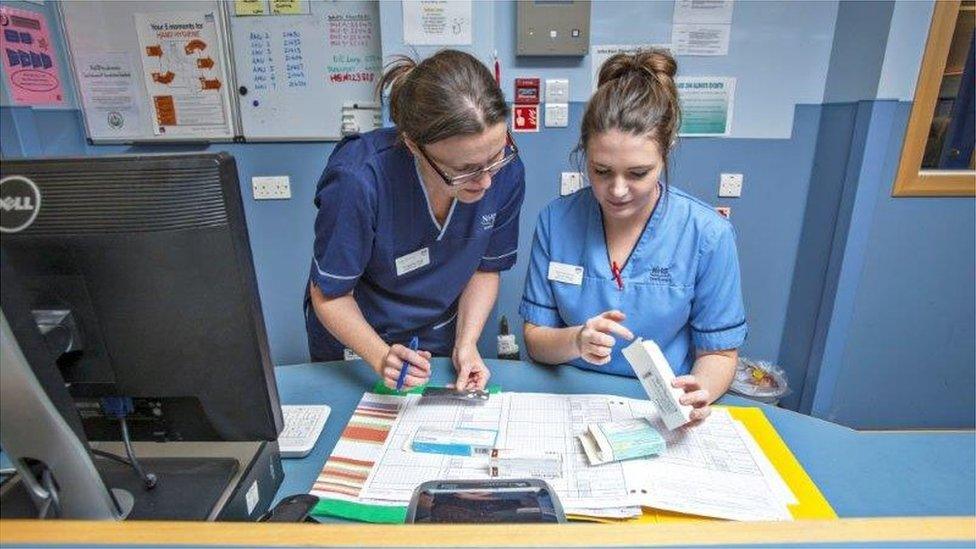 Nurses talking at a desk