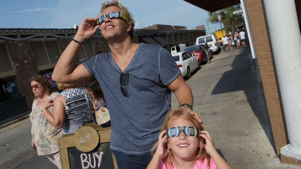 Nikos Spyridonos and his daughter Zoe try out eclipse glasses ahead of the total solar eclipse in Charleston, South Carolina, on August 20, 2017.