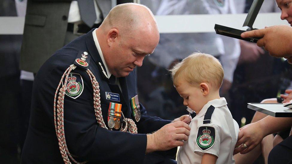 New South Wales Rural Fire Service (NSW RFS) shows RFS Commissioner Shane Fitzsimmons (L) pinning a medal on Harvey Keaton