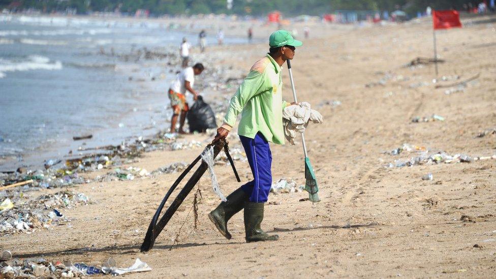 Person collecting rubbish at Kuta beach