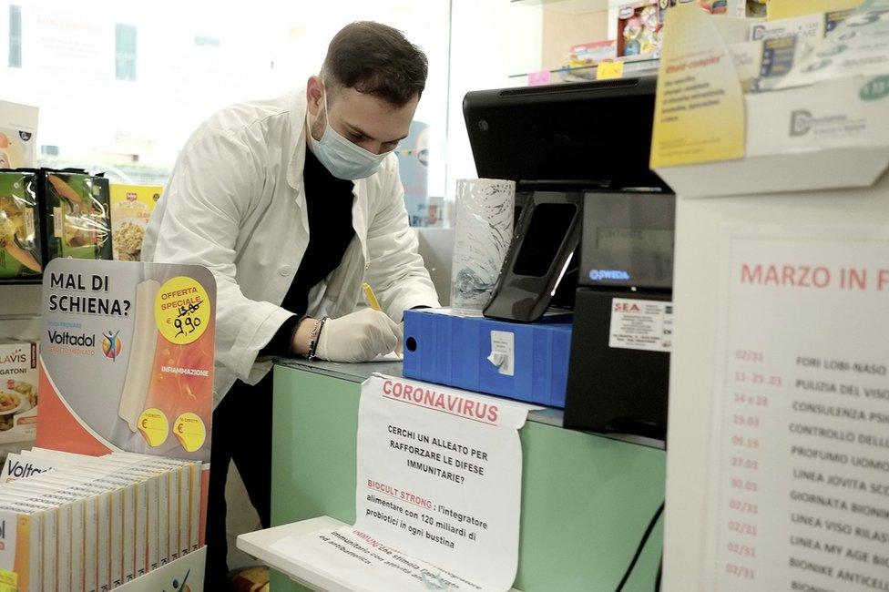 A doctor writing whilst working in a pharmacy in Rome