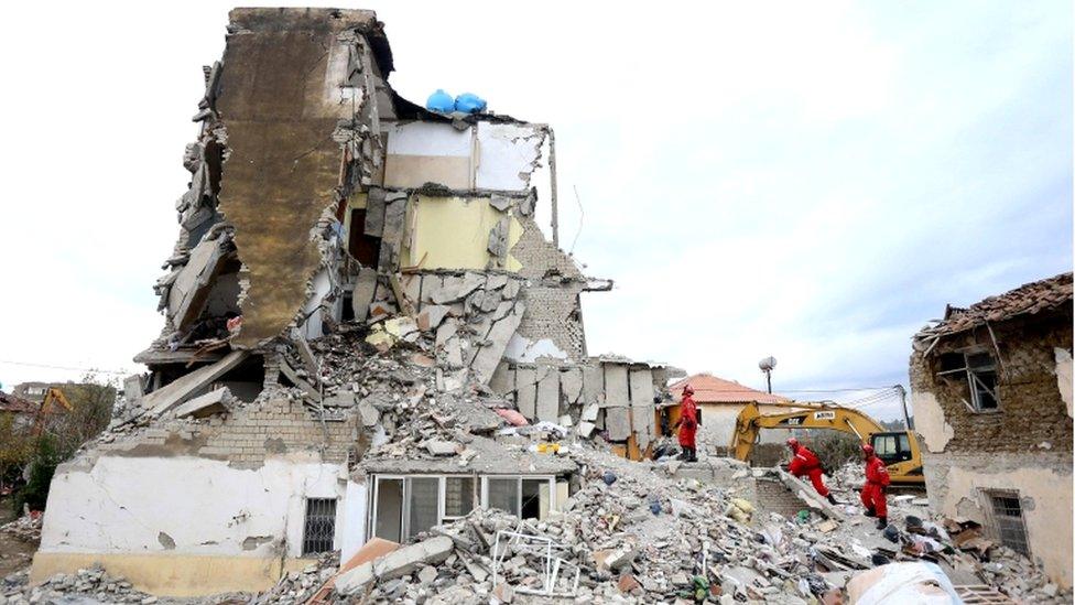 Italian rescuers search for survivors through the rubble of a collapsed building in Thumane, 27 November 2019