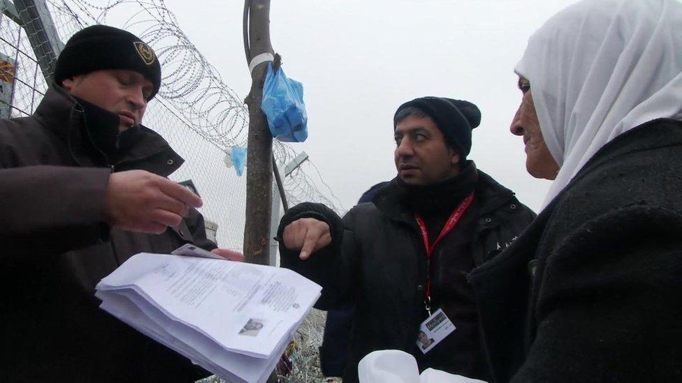 Border guards check a woman's papers