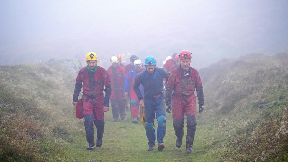 Rescue teams approach cave entrance