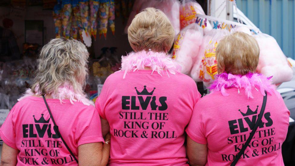 The back of three women wearing tops in tribute to Elvis