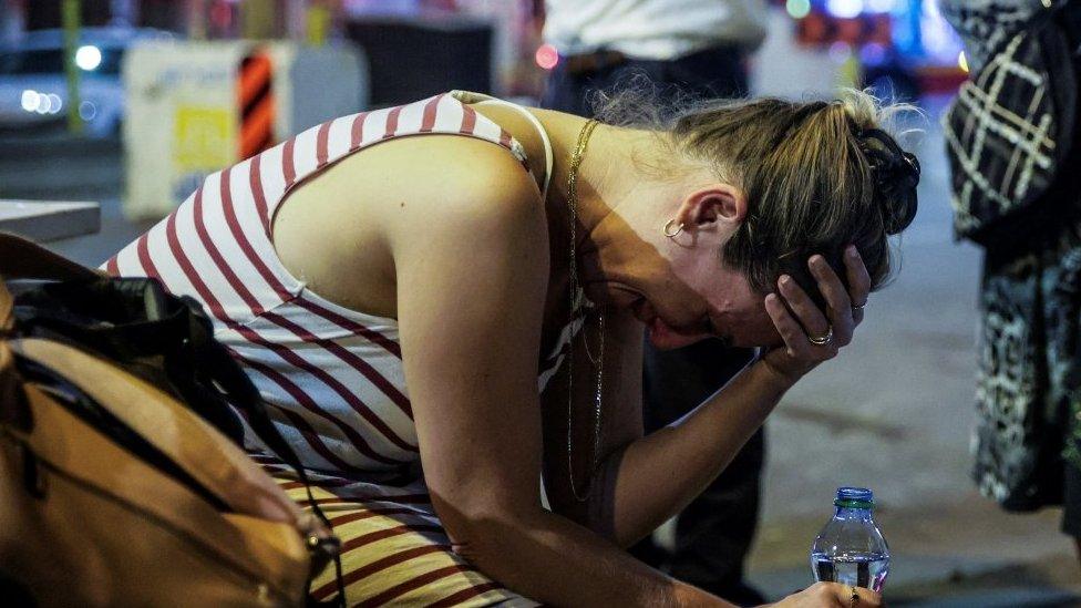 An Israeli woman holds her head in her hands in Tel Aviv