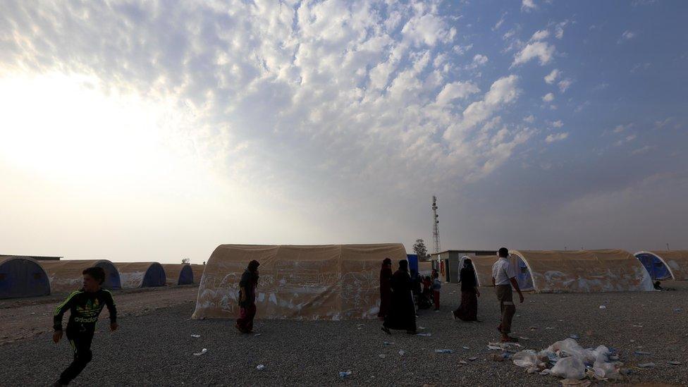 Newly-displaced Iraqis, who fled the violence in the northern city of Mosul as a result of a planned operation to retake the Iraqi city from jihadists, walk past tents upon their arrival at al-Khazar camp on October 27, 2016 in the village of Hasan Sham, some 40 kilometres east of Arbil, the capital of the autonomous Kurdish region.