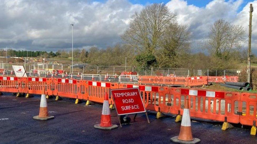 Lines of road cones and a temporary road surface sign