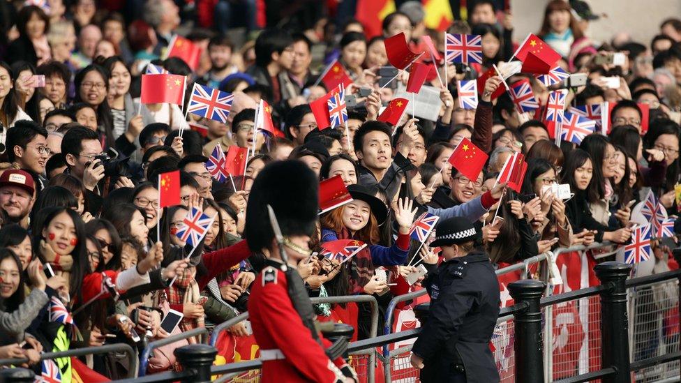 Spectators line the side of the Mall as they wait for Queen Elizabeth II and Chinese President Xi Jinping to pass