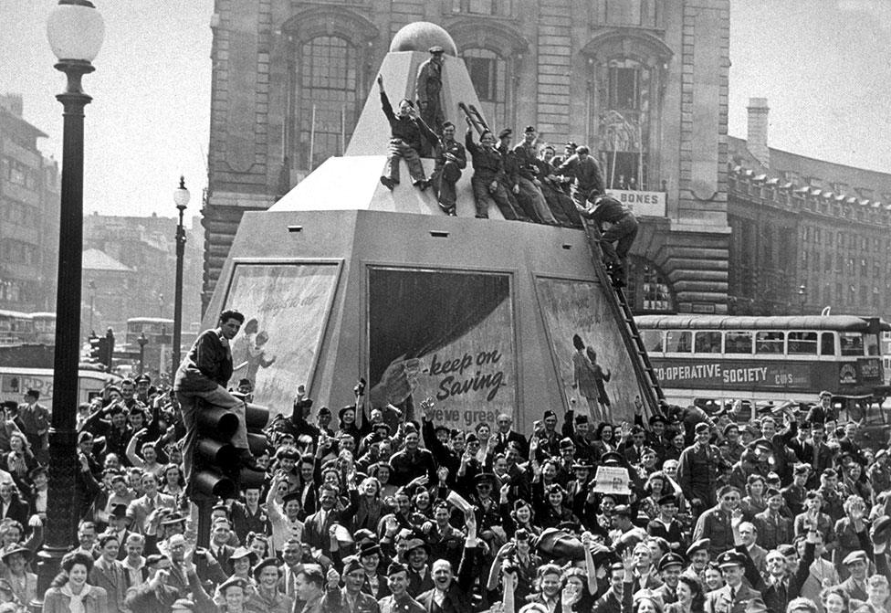 A crowd celebrates in Piccadilly Circus in London