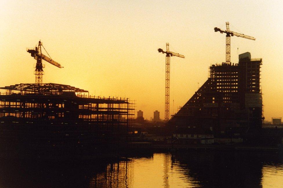 Three crane symmetry under construction at sunset