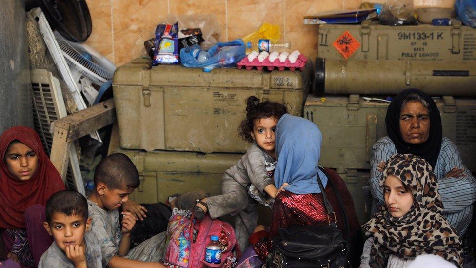 Displaced Iraqi civilians rest at an Iraqi security forces position in the Old City of Mosul (29 June 2017)