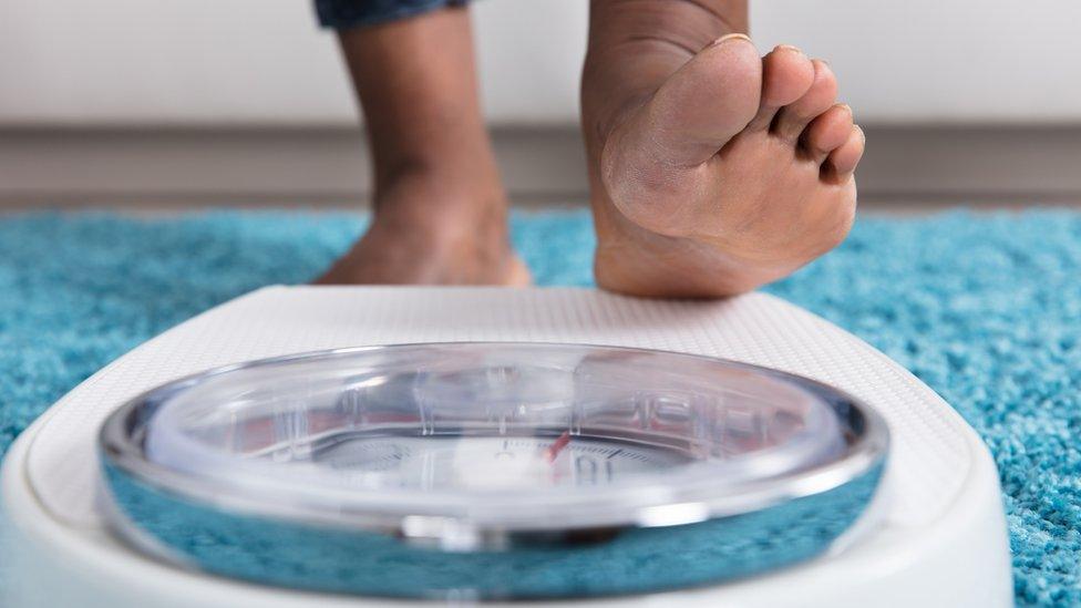 Woman standing on weighing scales