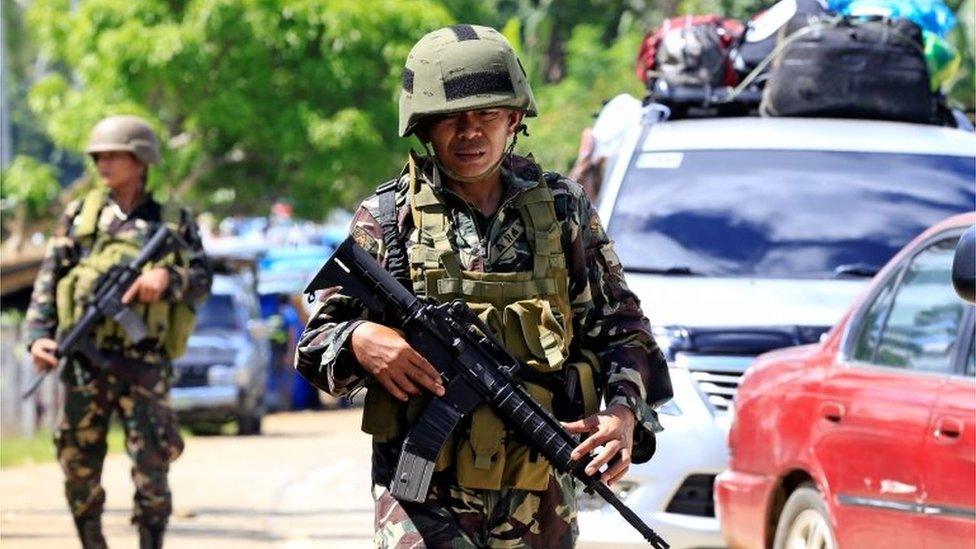 Government troops stand on guard during a checkpoint along a main highway in Pantar town, Lanao del Norte, after residents started to evacuate their hometown of Marawi city, southern Philippines May 24, 2017.