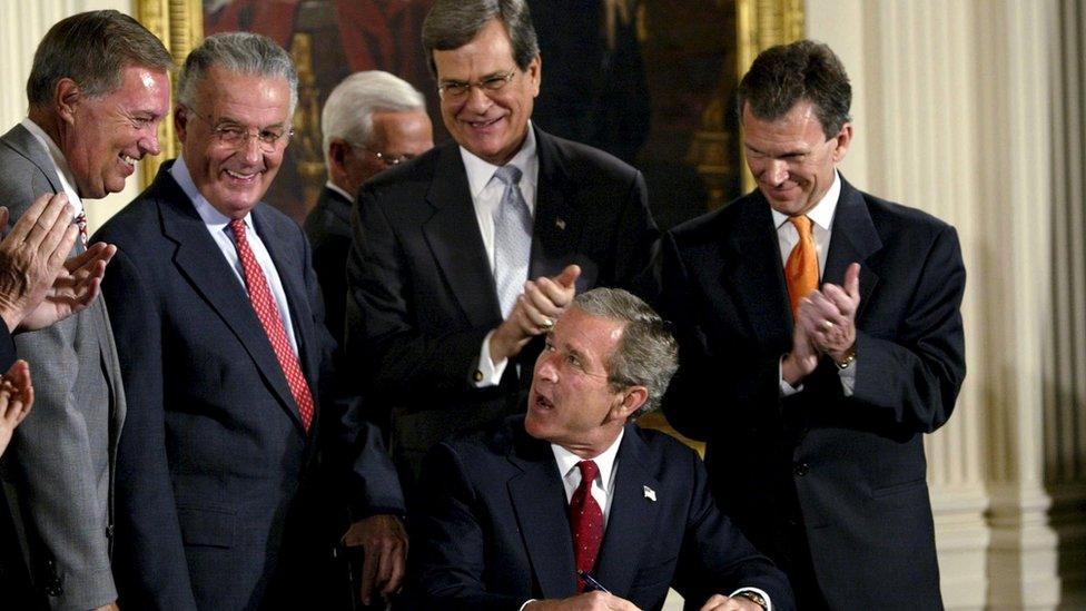 Former U.S. President George W. Bush is applauded after signing a bill that increases penalties for accounting fraud and provides new grounds for prosecuting corporate corruption, in the East Room of the White House, in this July 30, 2002 file photo.