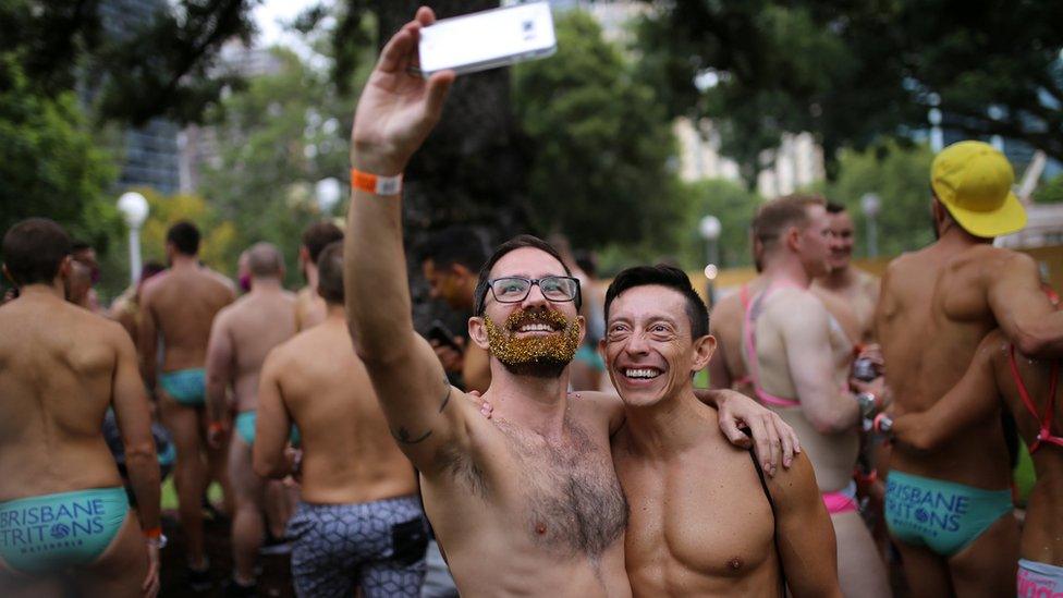 A shirtess male couple take a selfie during the annual Sydney Gay and Lesbian Mardi Gras festival in Sydney, Australia March 4, 2017.