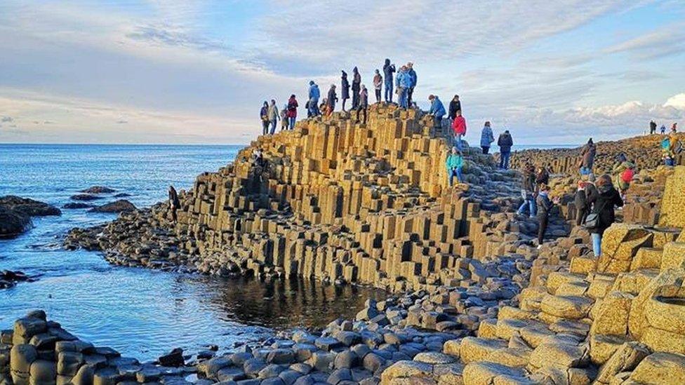 Y Côr ar eu taith o Ogledd Iwerddon eleni yn paratoi i ganu ar y 'Giant's Causeway'