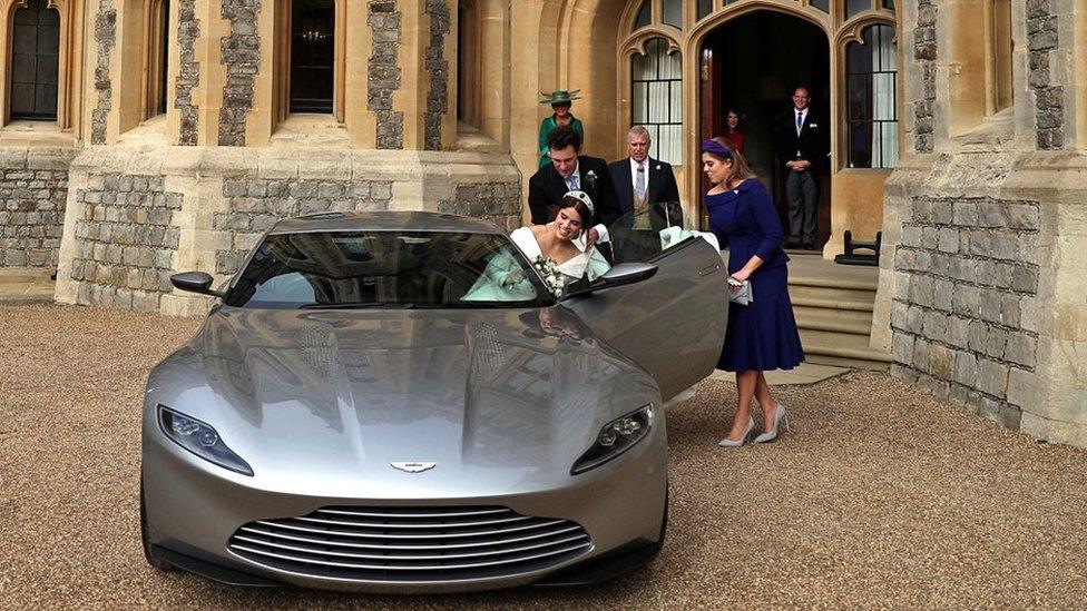 Jack Brooksbank and Princess Beatrice help Eugenie into the Aston Martin