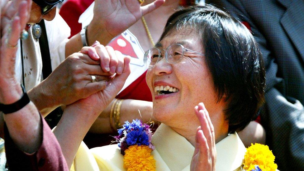 Japanese climber Junko Tabei, the first woman to summit Mt. Everest in 1975, is greeted by friends during a procession celebrating the 50th anniversary of the ascent