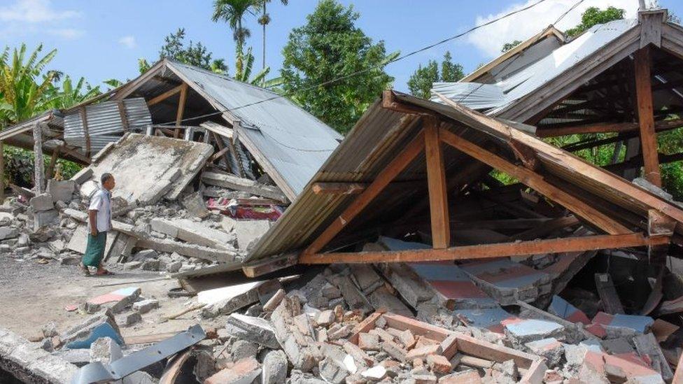 An Indonesian man examines the remains of houses, after a 6.4 magnitude earthquake struck, in Lombok on July 29, 2018.