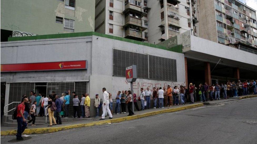 People line up to get into a Banco de Venezuela branch in Caracas, Venezuela December 13, 2016