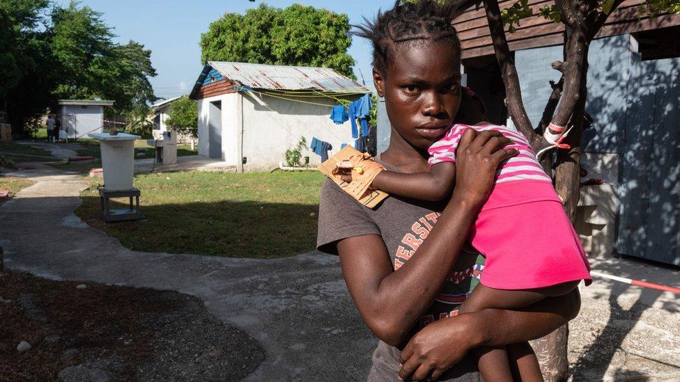 A young woman holds baby.