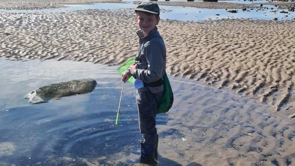 Riley stands in a large pool on the beach