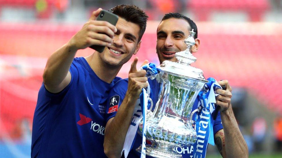Alvaro Morata of Chelsea and Davide Zappacosta of Chelsea take a selfie with the Emirates FA Cup Trophy following their sides victory in The Emirates FA Cup Final between Chelsea and Manchester United at Wembley Stadium on May 19, 2018 in London, England.