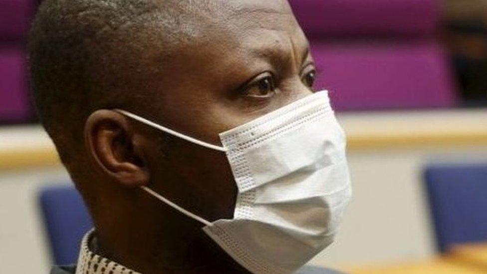 Sierra Leonean national Gibril Massaquoi, wears a face mask as he attends the first day of his trial at the Pirkanmaa District Court in Tampere, Finland