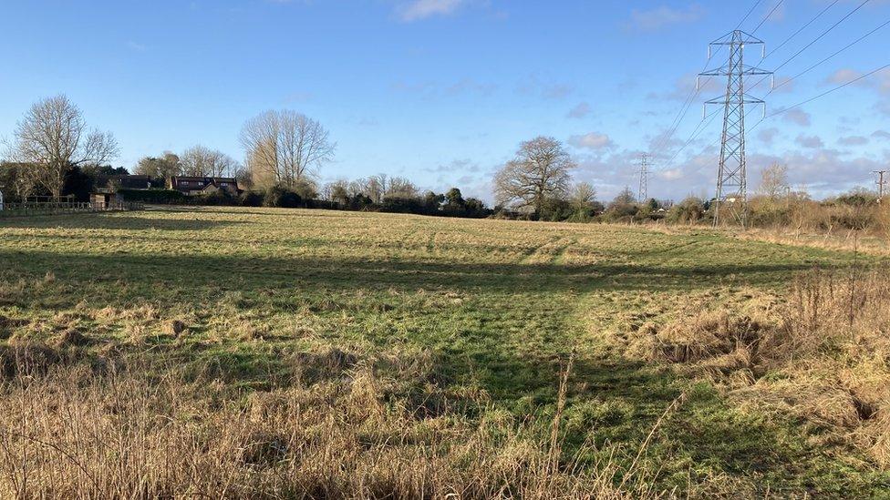 View of a field with some housing to the left