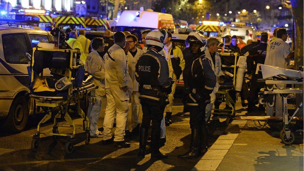 Rescuers and police stand by on Boulevard des Filles du Calvaire near the Bataclan concert hall in central Paris