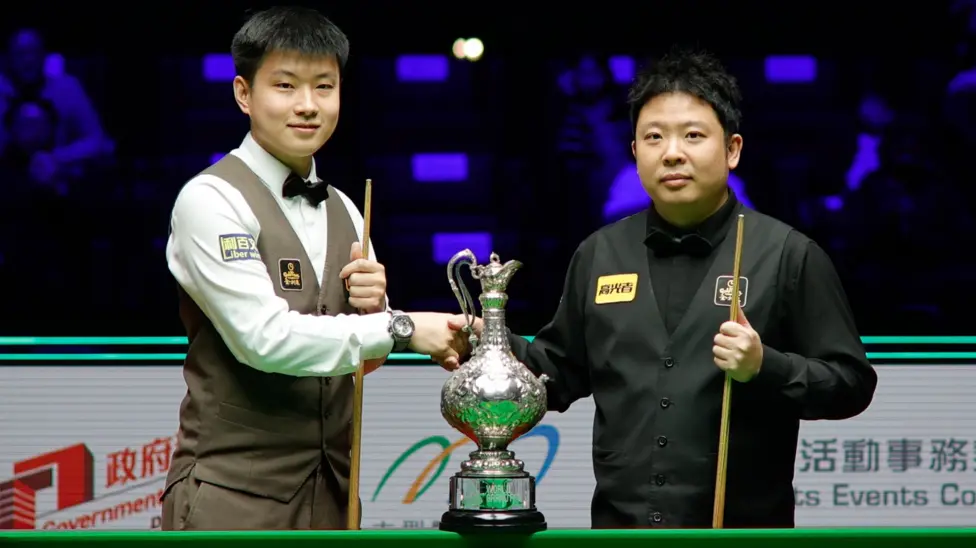 Zhao Xintong shakes the hand of Zhang Anda before the start of Sunday's World Grand Prix final in Hong Hong